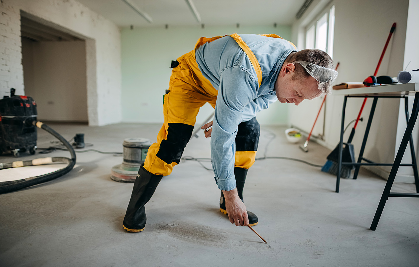 Bauarbeiter markiert auf Baustelle die Begrenzungen